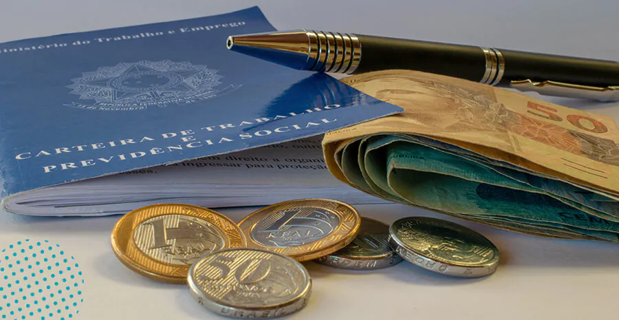 Carteira de Trabalho acompanhada de notas e moedas de real, simbolizando direitos trabalhistas e a aplicação do Artigo 473 da CLT para faltas justificadas.