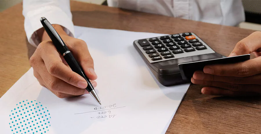 imagem de uma pessoa usando a calculadora e fazendo conta em um papel