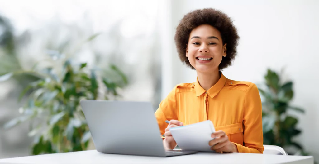 Mulher de laranja em frente a um computador