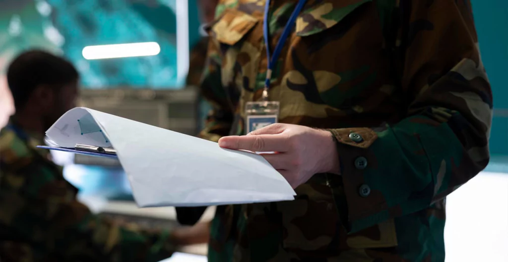 Militar analisando uma licença impressa presa a prancheta