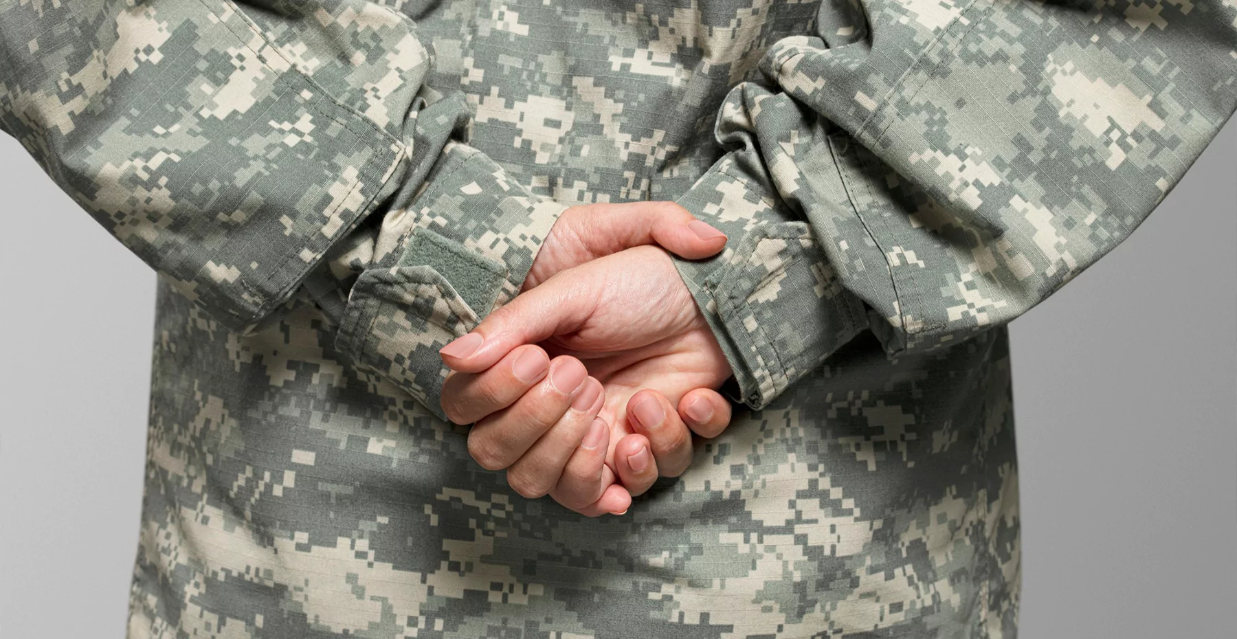 Militar de costas e com as mãos fechadas para trás